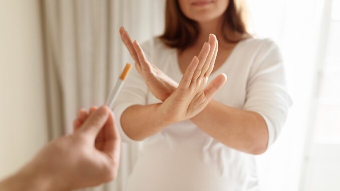 Pregnant woman refusing a cigarette in a well-lit indoor environment Fumeur en train de dire non à une cigarette après une séance d’hypnothérapie
